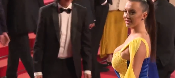 Katy Perry-lookalike protester dressed in Ukraine colors pours fake blood on herself on Cannes red carpet | Video